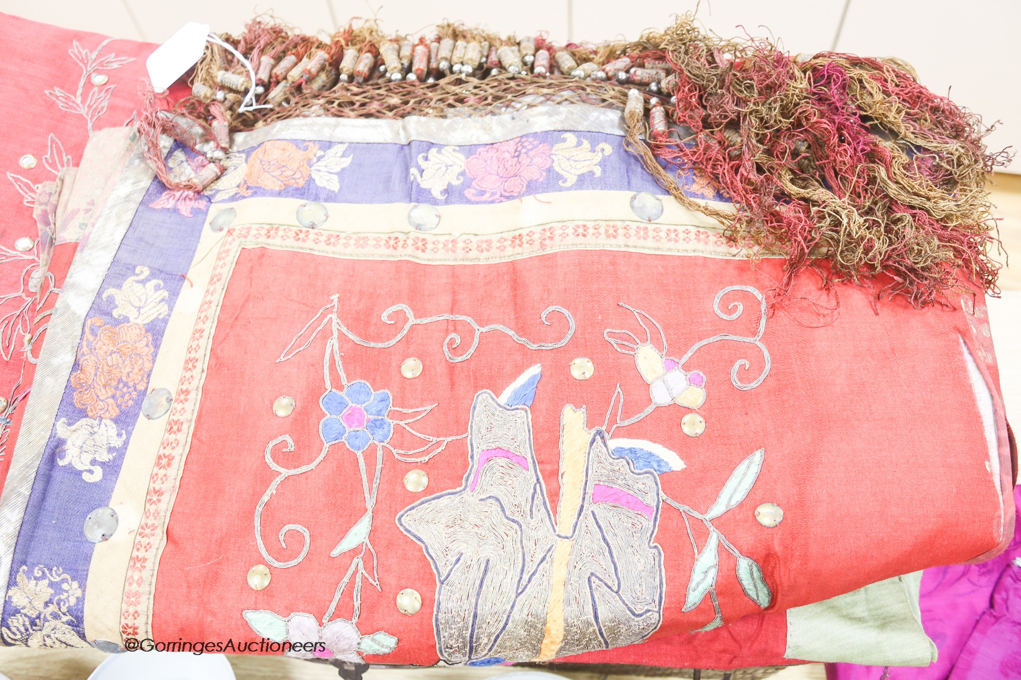 Two Chinese red silk hangings, a mauve damask hanging and a brightly coloured silk panel